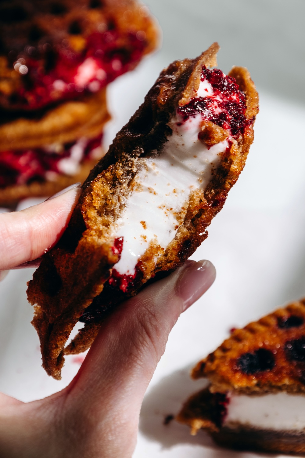 Nut free dairy free ice cream sandwich with freeze dried fruit coating with a bite out of it
