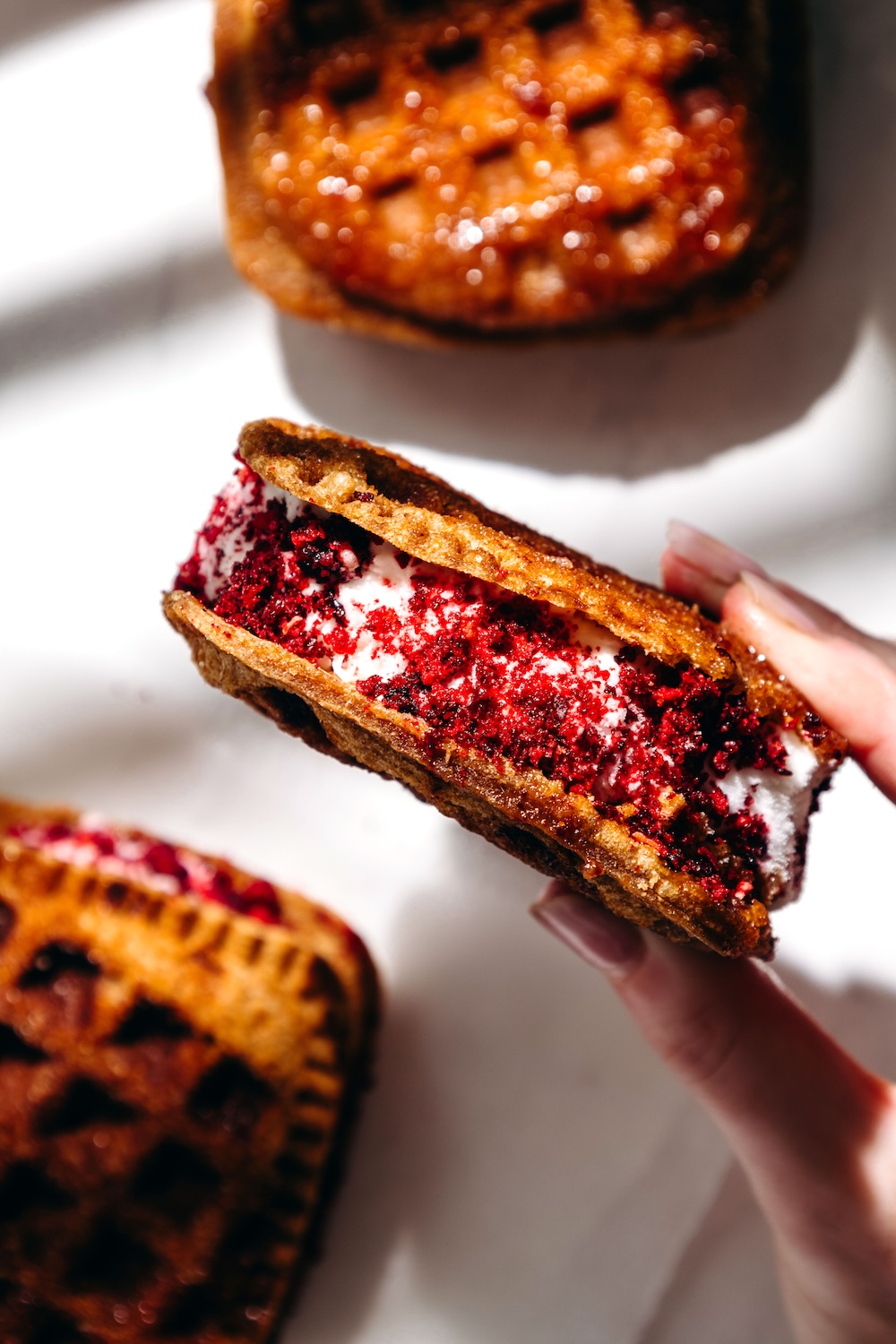 waffle iron PB&J ice cream sandwiches rolled in freeze dried grape dust in hand