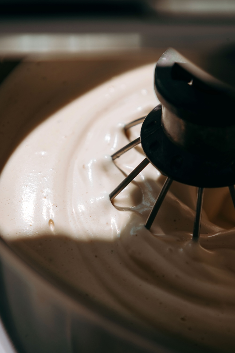 Stand mixer whisk whipping the protein marshmallow mixture into a thick, glossy base.