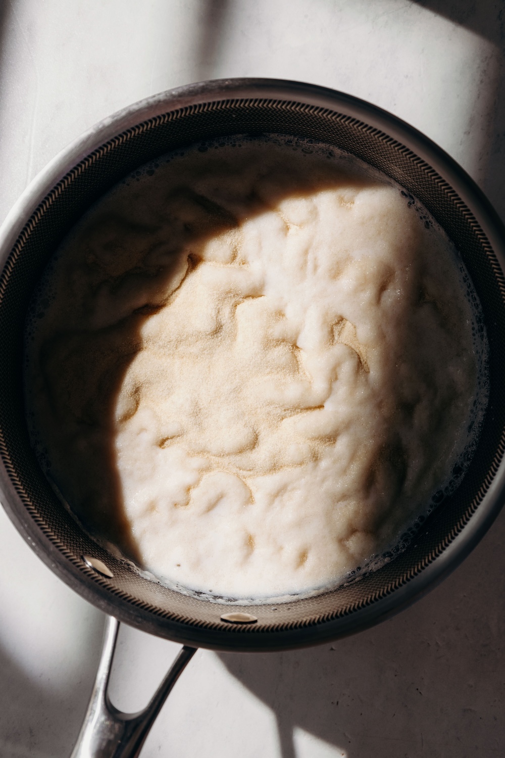 Gelatin blooming in almond milk in a stainless steel saucepan.